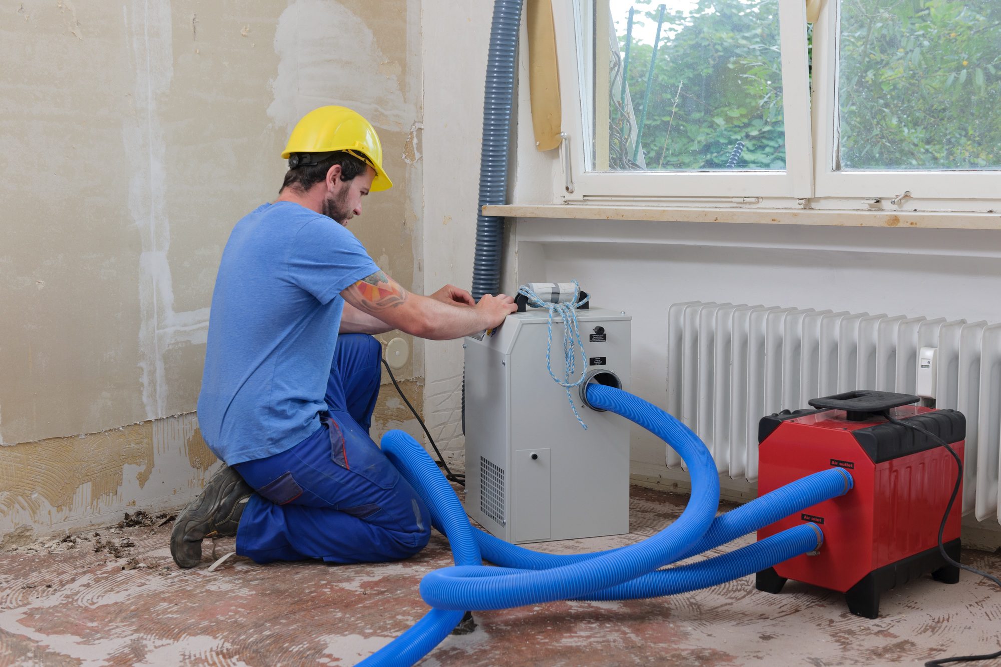 Worker adjusting dehumidifier in an apartment for mold Removal & Remediation